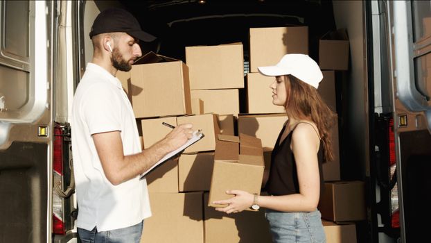 pexels photo 5025635 5025635 A male and female courier organizing packages in a delivery truck for efficient shipment.